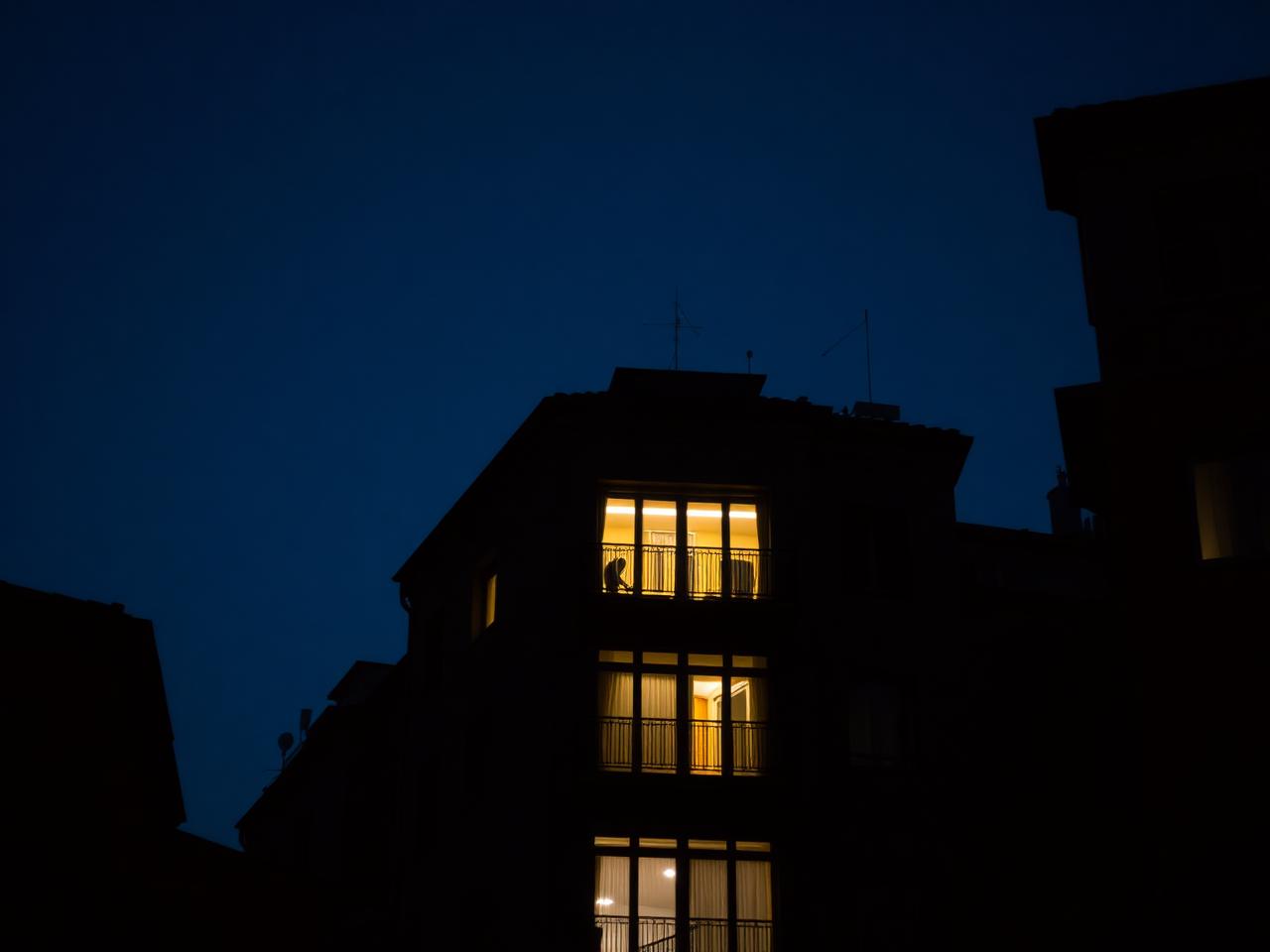 Finestra illuminata di un appartamento a Torino di notte