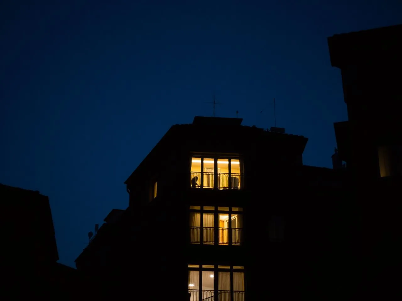 Finestra illuminata di un appartamento a Torino di notte